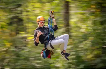 Person ziplining through trees at a Lancaster County PA amusement park