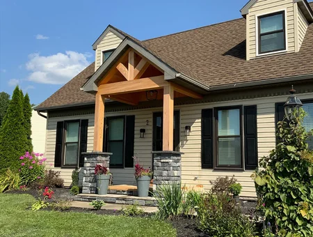 4JM Contracting home exterior remodel with new siding stone accents wood porch and landscaping in Lancaster PA