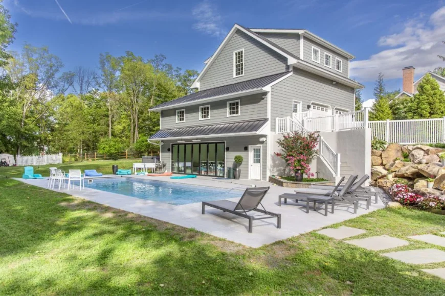 A & E Builders LLC backyard pool and home addition remodel in Lancaster PA with metal roof and stone landscaping