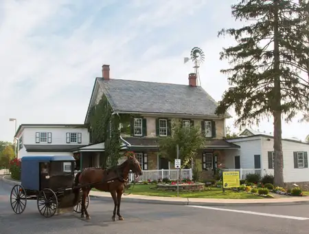 Amish Farm and House historic farmhouse exterior with horse and buggy Amish tour in Lancaster PA