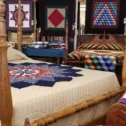 Amish handmade quilts on four poster bed at Lancaster County PA quilt shop