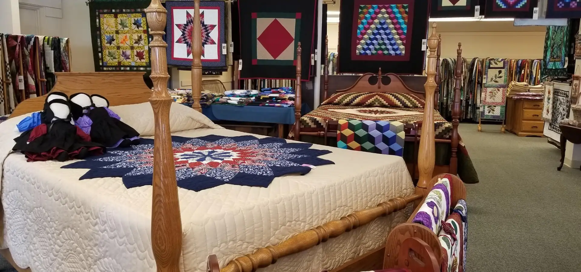 Amish handmade quilts on four poster bed at Lancaster County PA quilt shop
