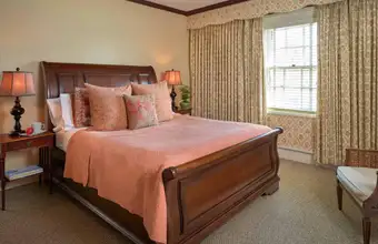 Elegant wood sleigh bed with warm bedding in a guest room at The Lancaster Bed and Breakfast in Lancaster PA
