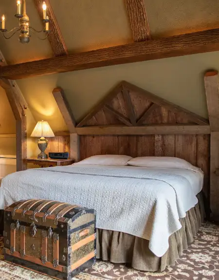 Rustic bed and breakfast room with exposed beams and antique trunk at Twin Pine Manor in Lancaster PA