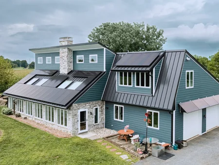 Belmont Solar solar panels installed on metal roof of blue green home with stone exterior in Lancaster PA