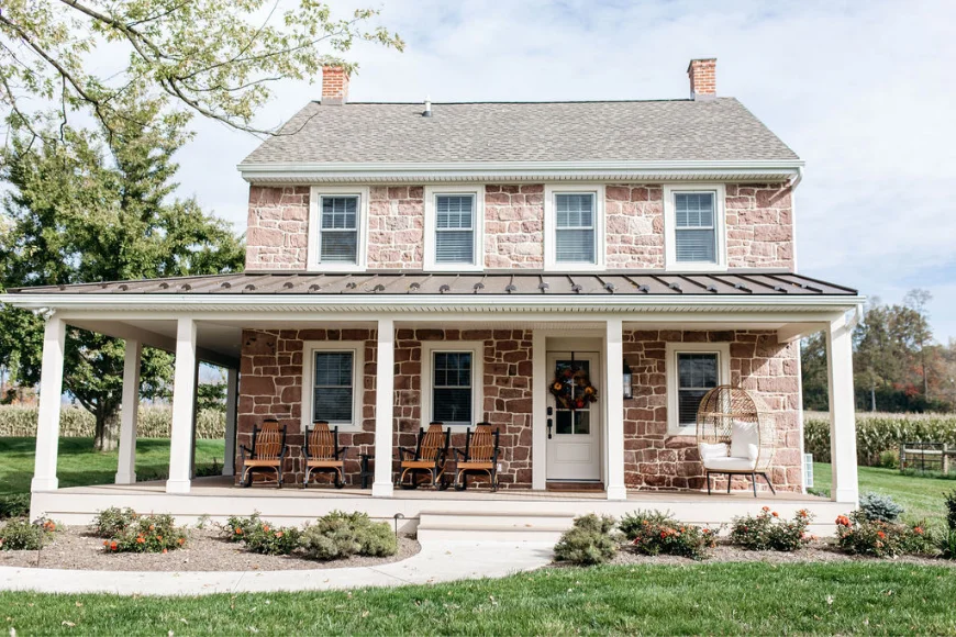 Brookside Brothers remodeled Lancaster PA stone farmhouse with wrap-around porch and metal roof