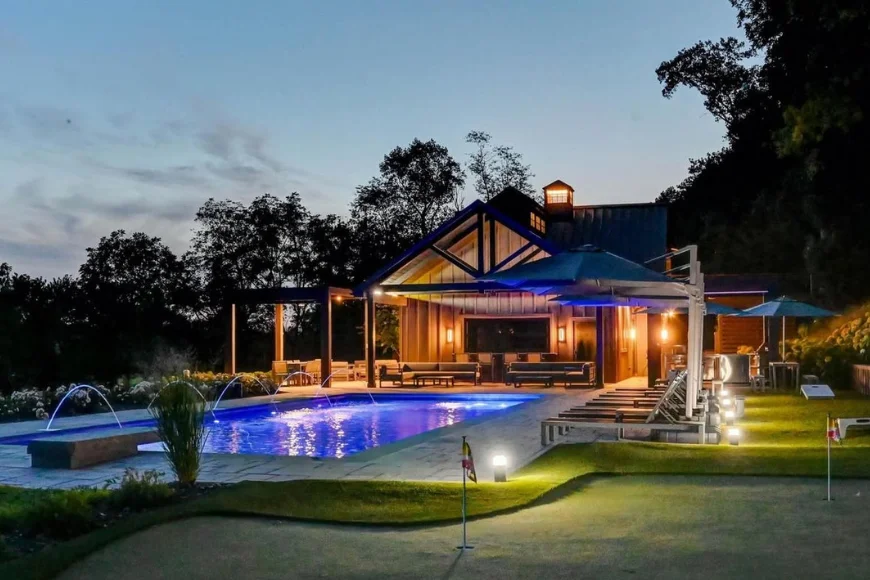 Conestoga Buildings custom pool house with lighted pool putting green and outdoor living area at dusk in Lancaster PA