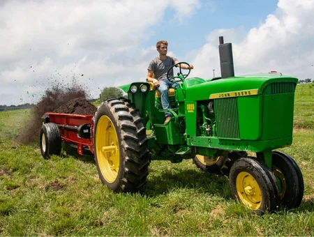 Conestoga Manufacturing John Deere tractor pulling red manure spreader in Lancaster PA farm field