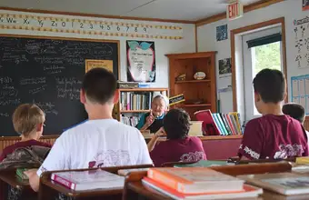 Children in Amish one-room schoolhouse on Lancaster County PA farm day trip