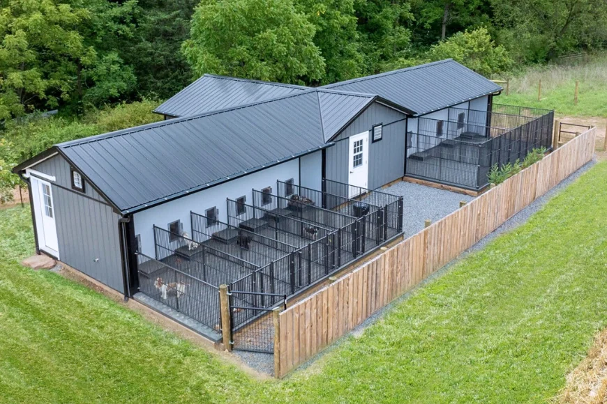 Aerial view of custom gray dog kennel building with outdoor runs and wood fence from The Dog Kennel Collection in Lancaster PA