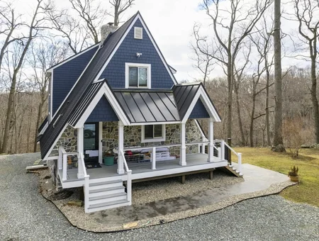 Navy blue metal roof with standing seam panels on A-frame home with white porch by DuraCraft Roofing in Lancaster PA