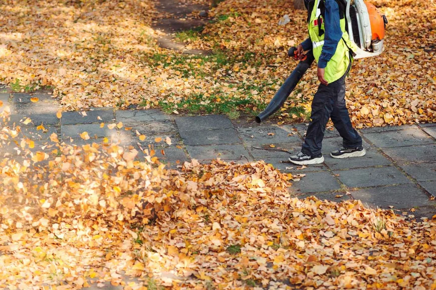 Landscaper using backpack leaf blower for fall leaf removal service by DWD Landscaping in Lancaster PA