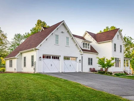 White farmhouse exterior with new siding and two-car garage by Eby Exteriors home transformation in Lancaster PA
