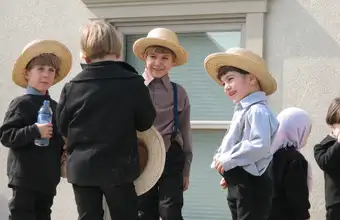 Amish children in straw hats attending Lancaster County PA mud sale community fundraiser