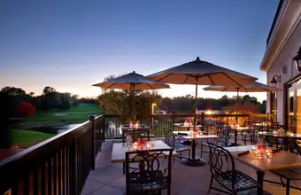 Outdoor patio dining with umbrella tables overlooking a golf course at DoubleTree Resort in Lancaster PA