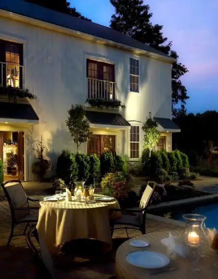 Outdoor dining by the pool at dusk at Inn at Leola Village resort in Lancaster PA