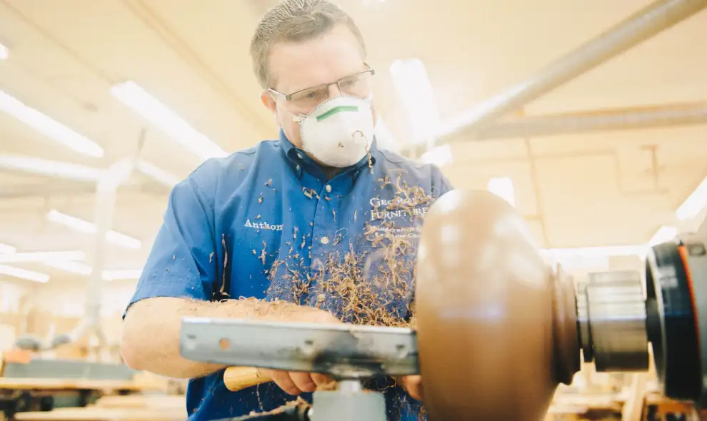 Georges Furniture craftsman turning wood furniture leg on lathe in Lancaster PA workshop