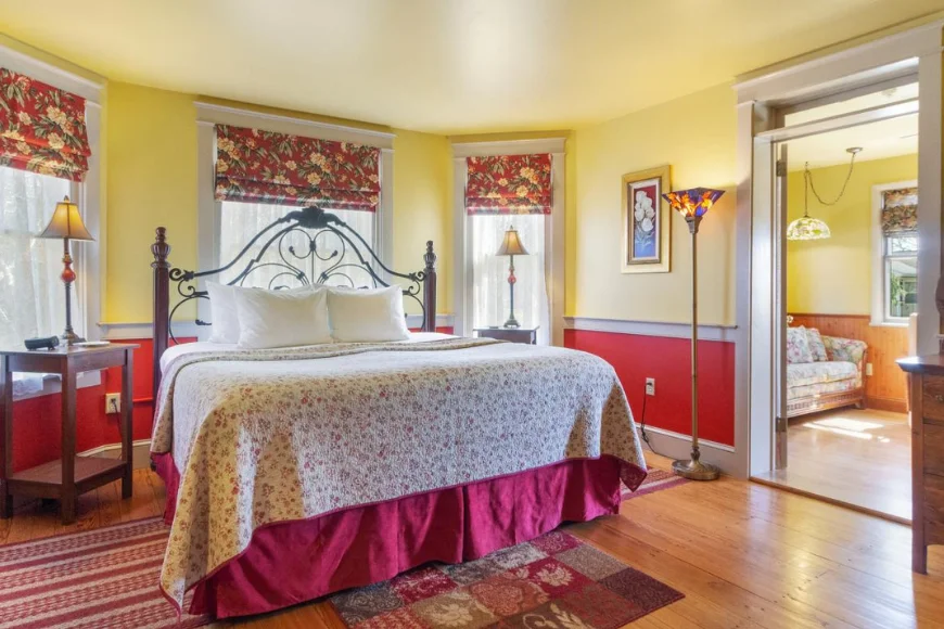 Bedroom with iron bed frame and floral decor at After Eight Bed and Breakfast in Amish Country PA