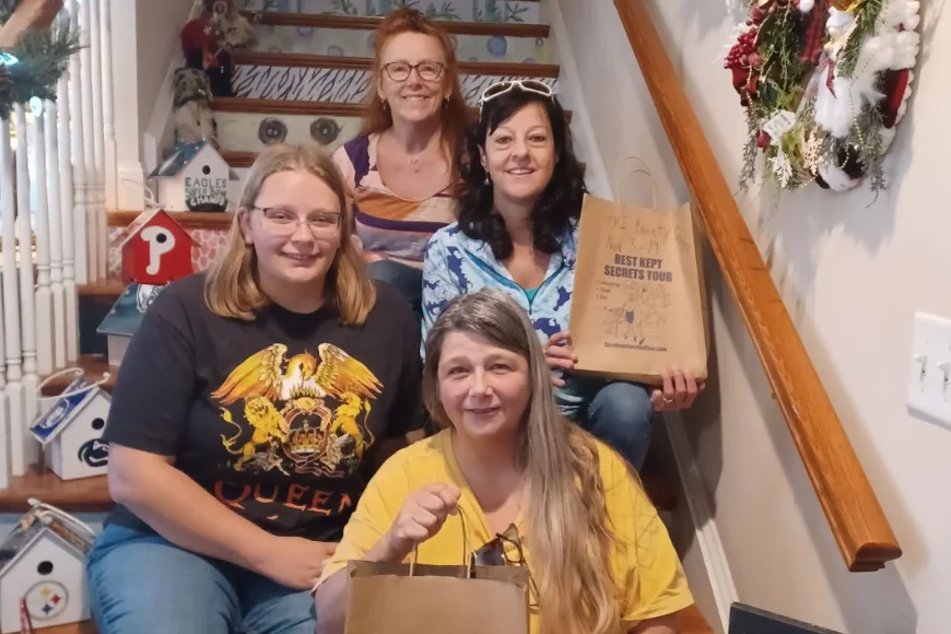 Group of women on a staircase holding shopping bags on the Best Kept Secrets Tour in Lancaster PA