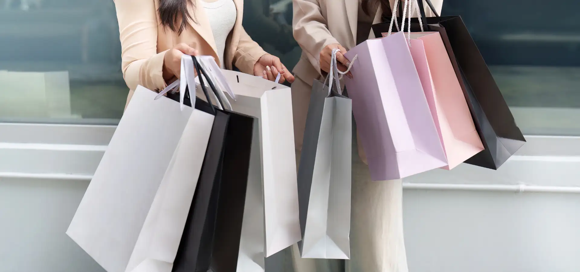 Black Friday shoppers carrying multiple gift bags in Lancaster, PA, showing an armful of black, white, and pink shopping bags