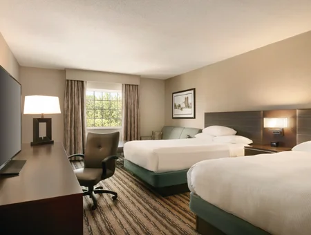 Double queen guest room at DoubleTree Resort by Hilton Lancaster, with striped carpet, a work desk, TV, and a window with soft natural light