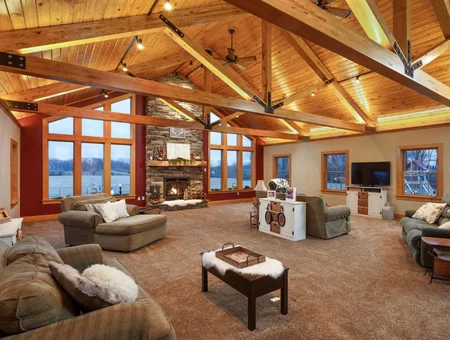 Living room with vaulted wood ceiling, stone fireplace, and waterfront views built by Earl Weaver Contractors in Lancaster County PA