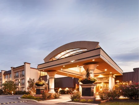 Curved illuminated entrance canopy at Eden Resort and Suites at dusk