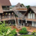 Rustic lodge exterior with wraparound deck and spiral staircase at Twin Pine Manor in Ephrata PA