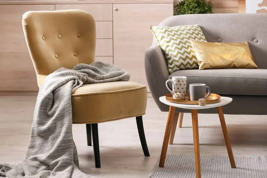 Shady Maple Gift Shop mustard chair, gray sofa, and side table styled with pillows and mugs