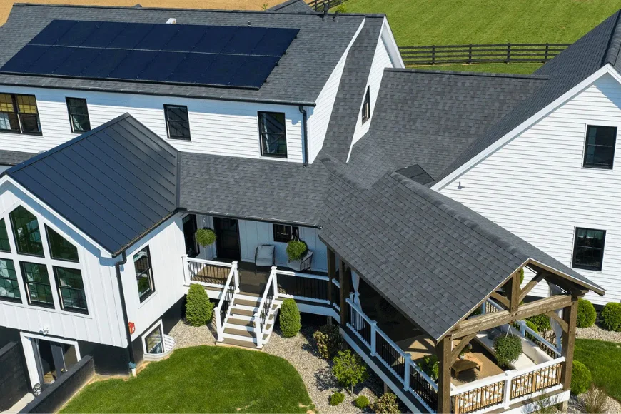 Aerial view of a farmhouse roof with solar panels and covered deck installed by Edge View Roofing in Lancaster County PA