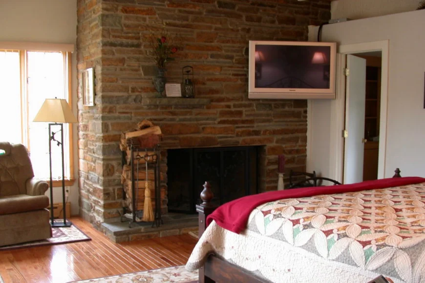 Bedroom with stone fireplace and quilted bed at Shallowbrook Farm in Lancaster PA