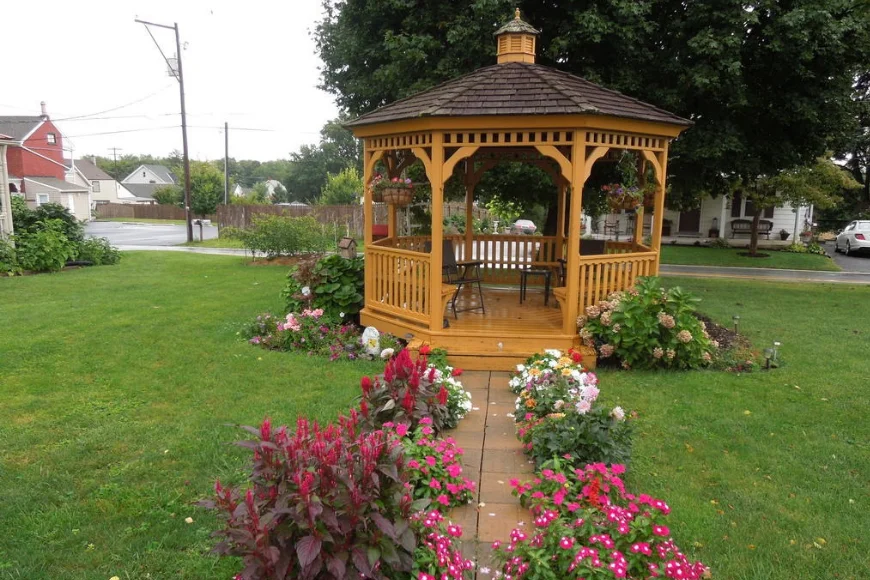 Wooden gazebo surrounded by a flower lined garden path at Red Carpet Inn in the Amish Country region of Lancaster PA
