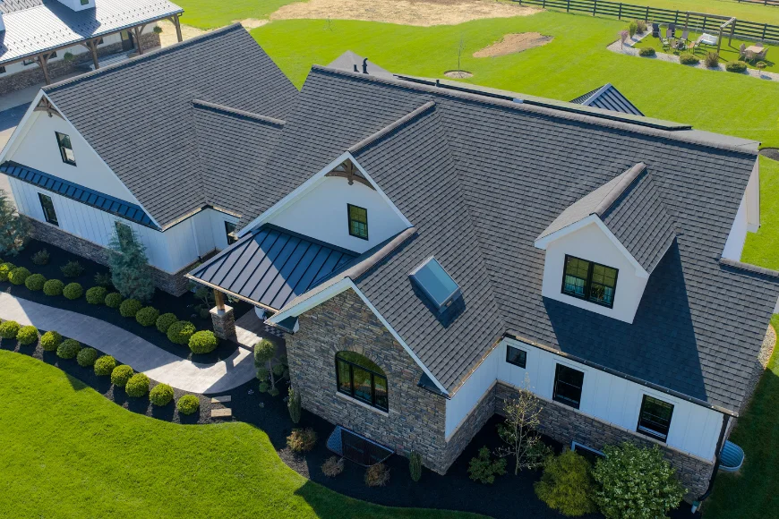 Aerial view of a multi gable stone home roof with skylights installed by Edge View Roofing in Lancaster County PA