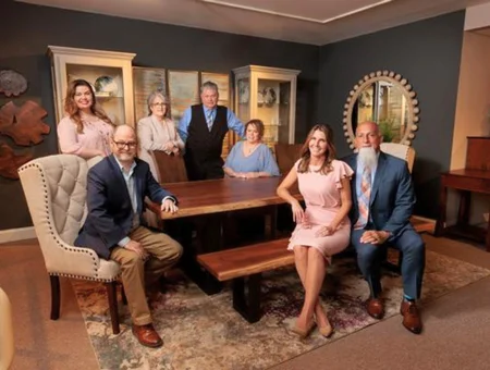 Gish's Furniture team gathered around a wood dining table in a showroom, Lancaster PA family business