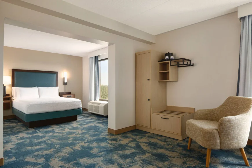 Guest room with king bed and lounge chair at Hampton Inn Lancaster PA
