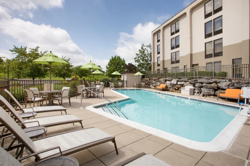 Outdoor pool with lounge chairs and patio seating at Hampton Inn Lancaster PA