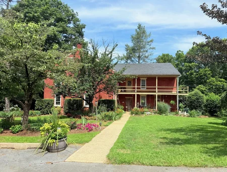 Brick farmhouse exterior with landscaped walkway at Hillside Farm Bed and Breakfast in Lancaster PA