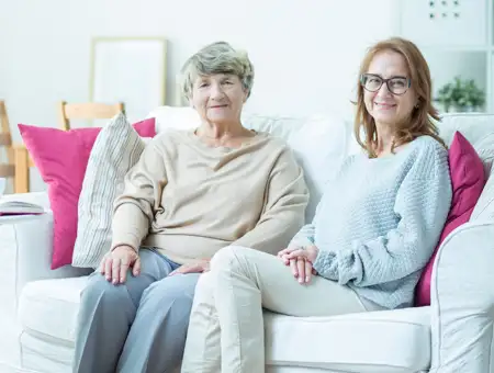 United Zion home care caregiver visiting with senior client on couch in Lancaster PA