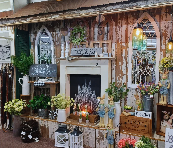 Rustic shop display with a vintage fireplace mantel, arched mirrors, flowers, and decorative signage, home page hero from best kept secret tour for LancasterPA.com shopping