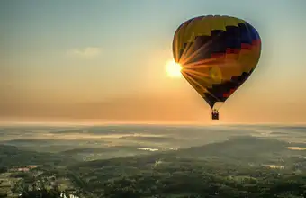 Lancaster Balloon Rides hot air balloon flying over countryside at sunrise