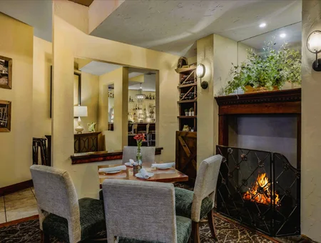 Dining table by fireplace with wine bar in background at The Inn at Leola Village in Lancaster PA