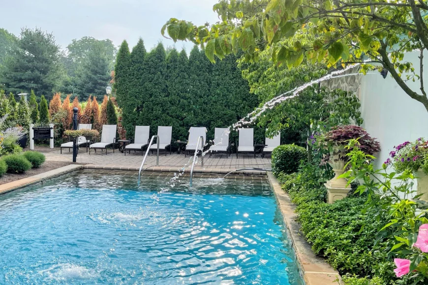 Fountain jetting into pool surrounded by lounge chairs at The Inn at Leola Village in Lancaster PA
