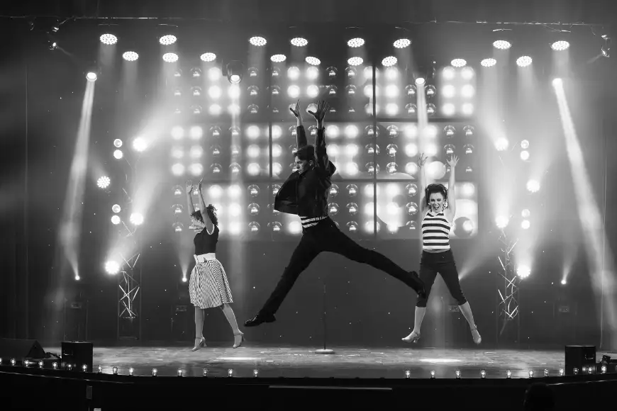 Jukebox Generation black and white dancers leaping under stage lights at Magic and Wonder Dinner Theater in Lancaster PA