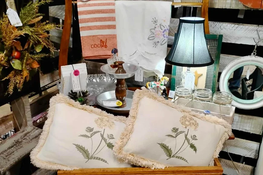 Embroidered floral throw pillows displayed with vintage home decor at Kindred Collections
