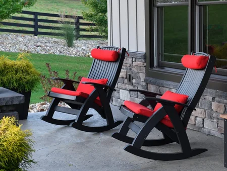 Black outdoor rocking chairs with red cushions on a stone patio, Kings Amish Furniture