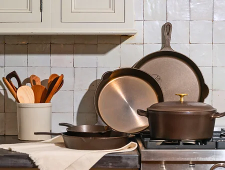 Alt text: Cast iron skillets, Dutch oven, and wooden utensils displayed on a stovetop