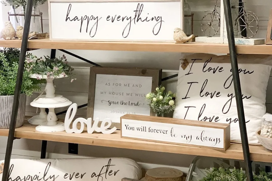 Farmhouse decor shelf with "happy everything" sign, framed scripture art, and love-themed pillows and signs