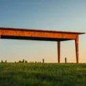 Handmade wooden farm table displayed outdoors in a grassy field at sunset in Lititz, PA