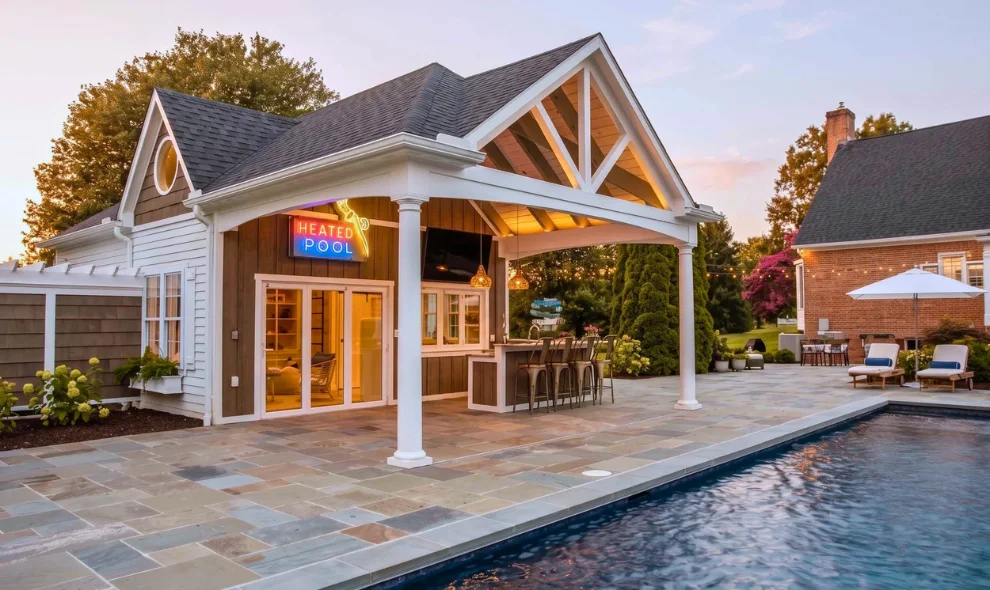 Pool house with covered patio, illuminated pool sign, and bar seating beside pool at dusk, Lancaster PA outdoor structures