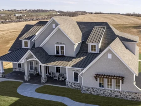 Aerial view of large custom home with dark shingle roof and stone accents, Lancaster PA roofing contractor